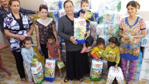 A group of women pose with their children after receiving their diaper supply.